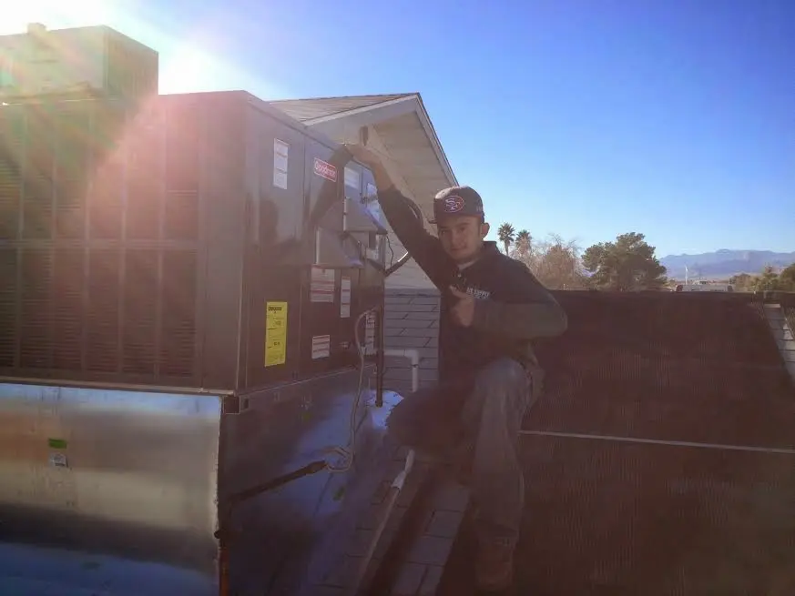 HVAC technician performing Air Duct Repair on a rooftop unit in Jackson